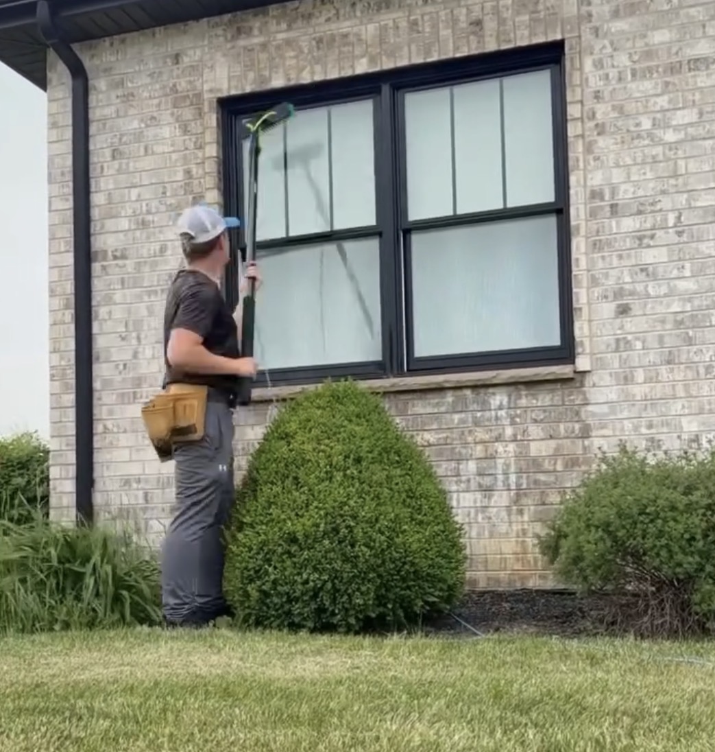 Prime Shine crew member washing residential exterior windows with a water-fed pole